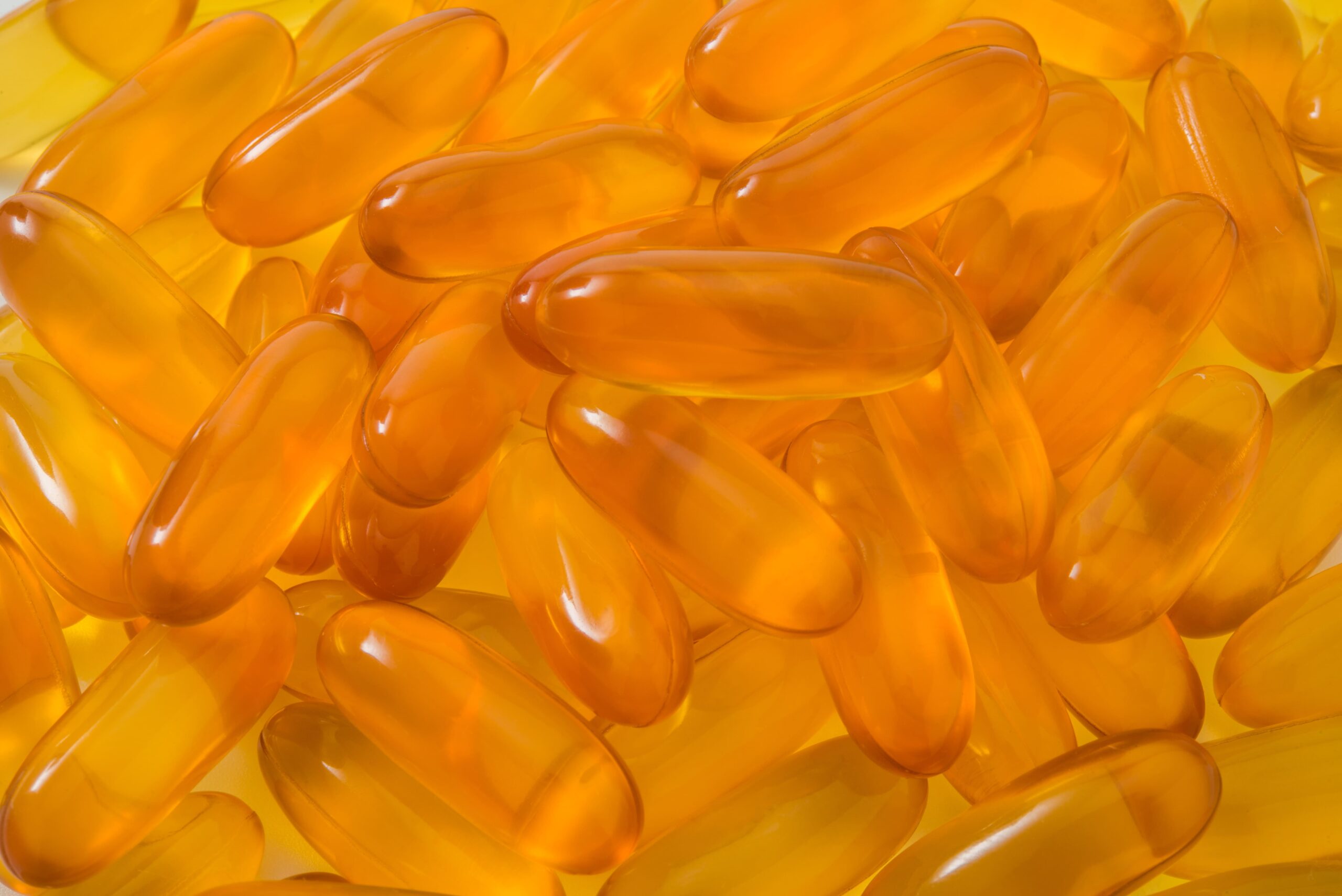 Capsule nutraceutiche arancioni per formulazioni con carotenoidi e vitamine.